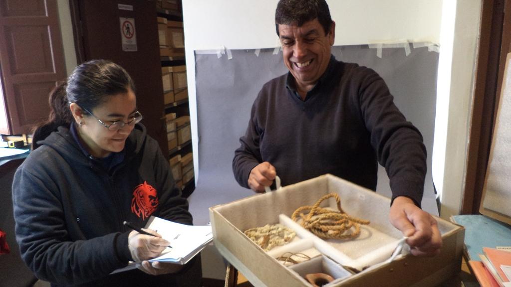 Guillermo Villar, encargado del Depósito del Museo del  Limarí junto a Iris Moya revisando el contenido de una caja con objetos asociados a un ajuar funerario.