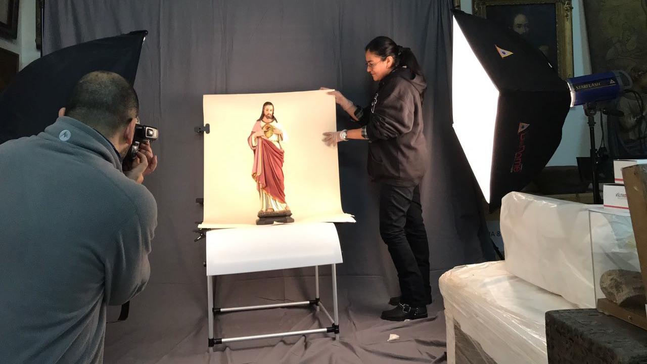 Francisco Mora e Iris Moya realizando tomas fotográficas de una imagen religiosa en el estudio montado en el MRR.