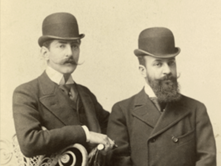 Dos figuras masculinas vistiendo sombrero hongo